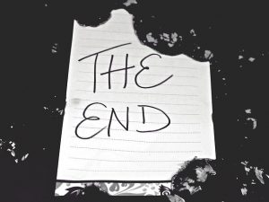 "The End" written on a ragged piece of notebook paper against a black background