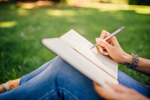 Woman in jeans writing in journal