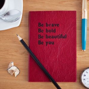 Red book with inspirational quote: "Be brave. Be bold. Be beautiful. Be you." 