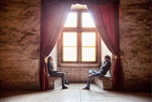 Two people talking in a window nook